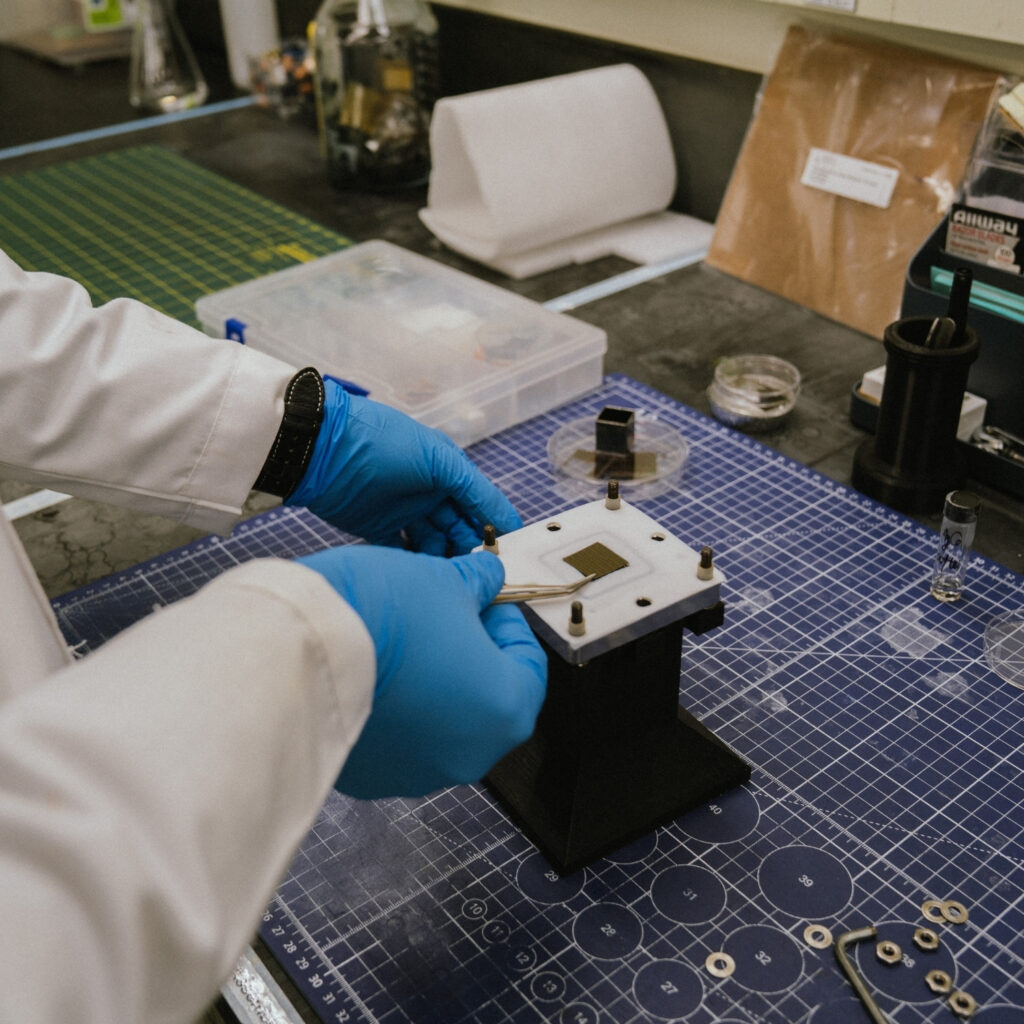 Reza's hands placing a small square on a device