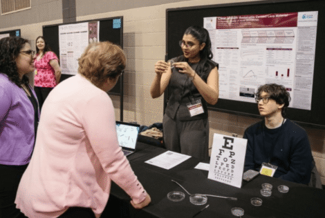 Heather Sheardown talks to a student demonstrating a project at the capstone showcase.