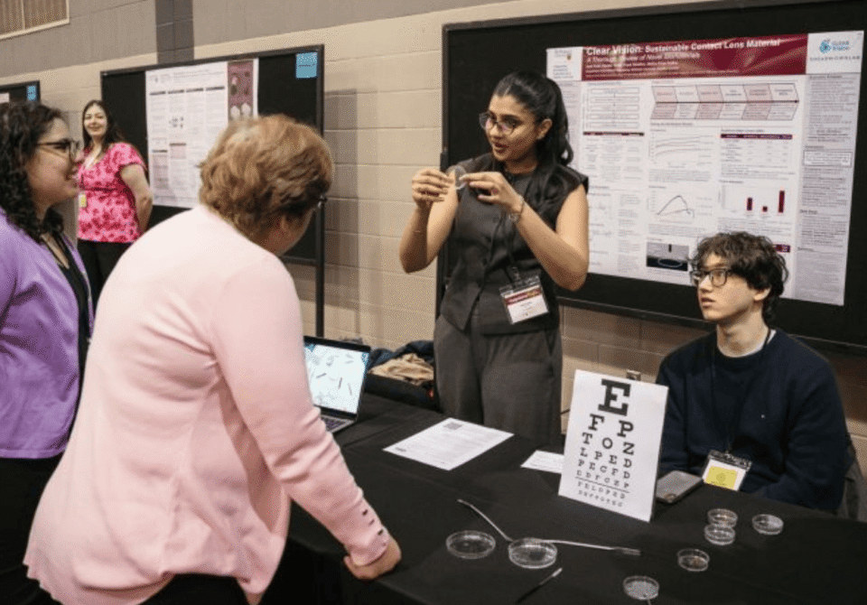 Heather Sheardown talks to a student demonstrating a project at the capstone showcase.