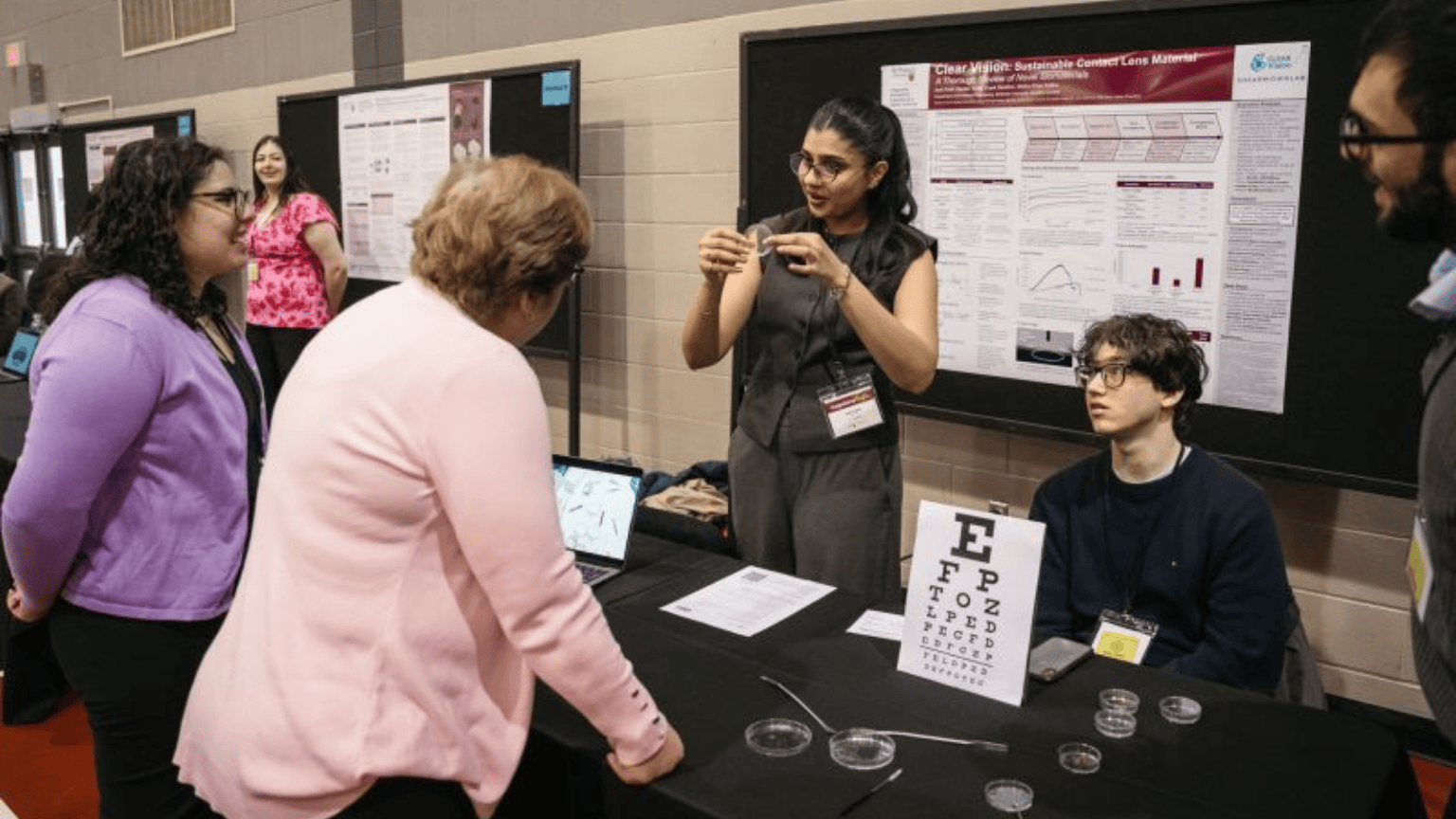 Heather Sheardown talks to a student demonstrating a project at the capstone showcase.