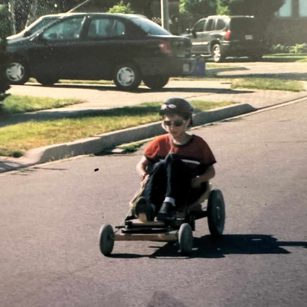 Young Nathan on a small kart on a road