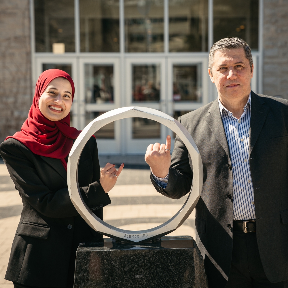 Yara and Wael pose at the iron ring statue.