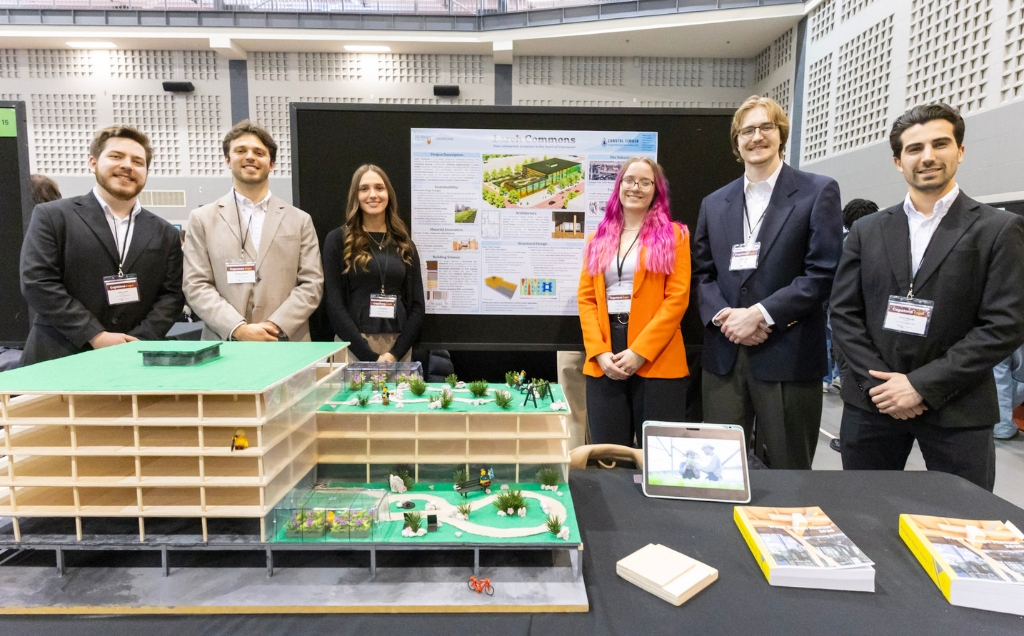 The Civil Capstone team at their expo booth with a large building display on their table