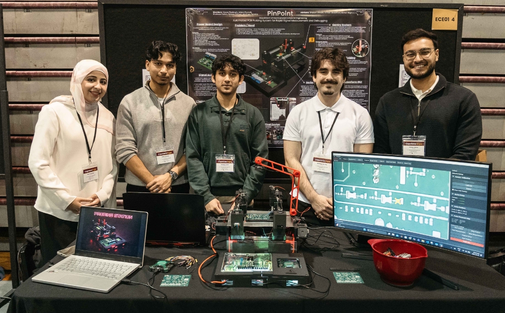 The PinPoint team poses with their prototype displayed on their table