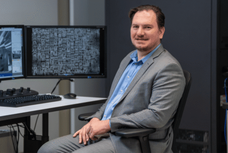 Nabil Bassim sits in front of a desktop computer.
