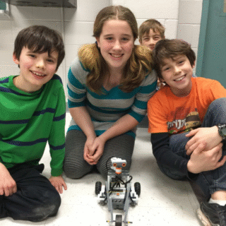 Kids posing with a robot at Venture Summer Camp in 2015