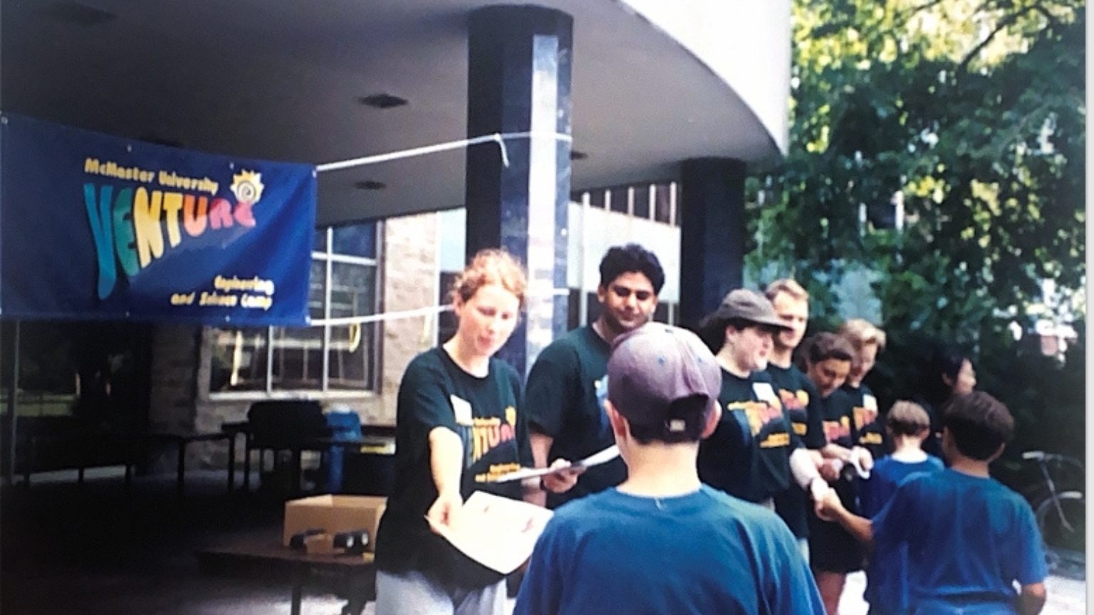 Venture staff passing out packages to youth in front of JHE