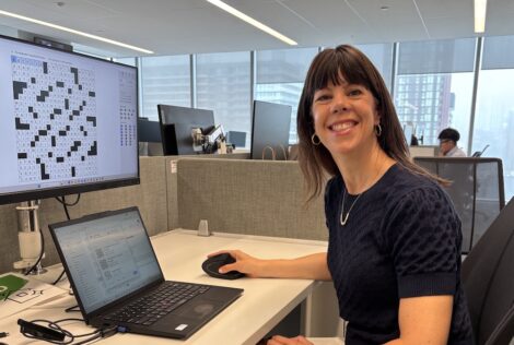 Jess Shulman, a Mac Eng graduate sitting at her desk at the Globe and Mail.