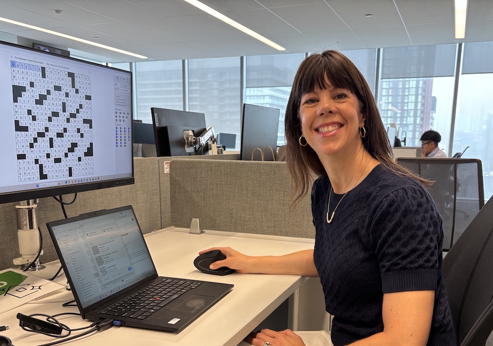 Jess Shulman, a Mac Eng graduate sitting at her desk at the Globe and Mail.