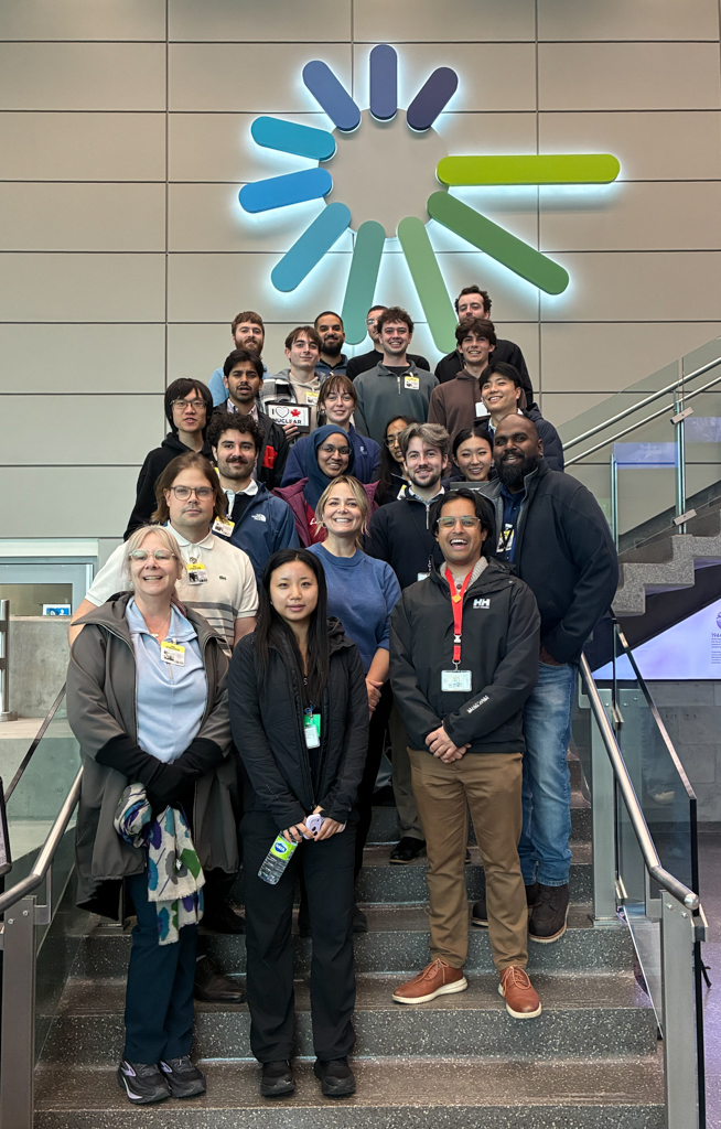 Students pose on a staircase under the Canadian Nuclear Laboratories logo. 