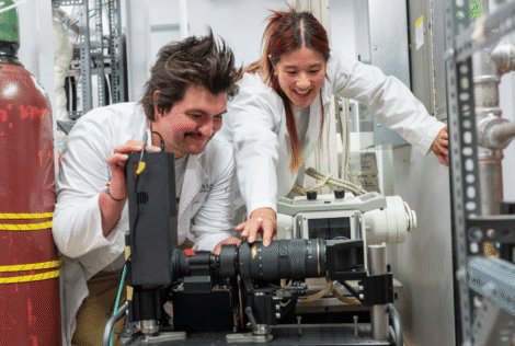 Nuclear engineering PhD students Jessica Lo and Clayton Vrenjak looking at camera/detector in NRB.