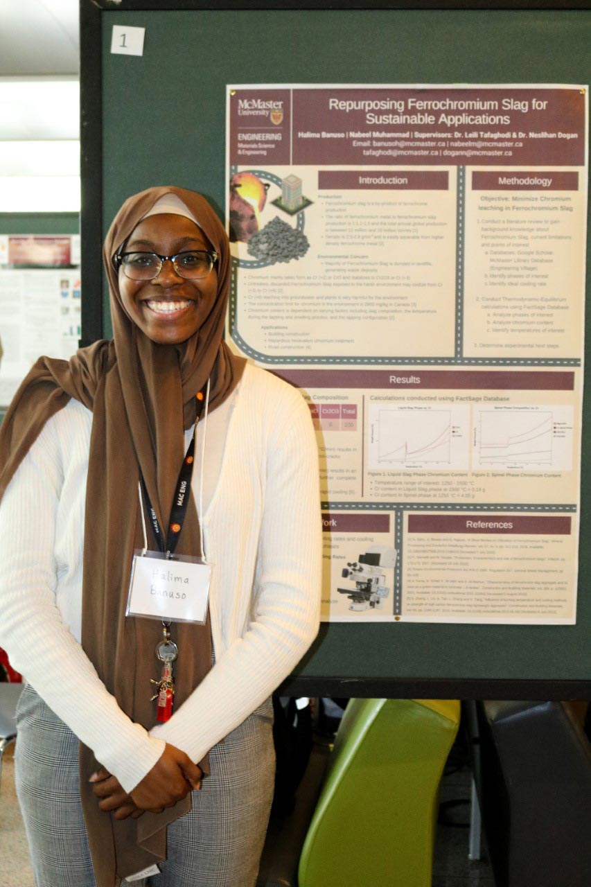 Halima stands with her research poster