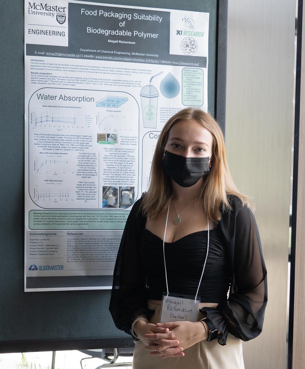 Abigail stands with her research poster