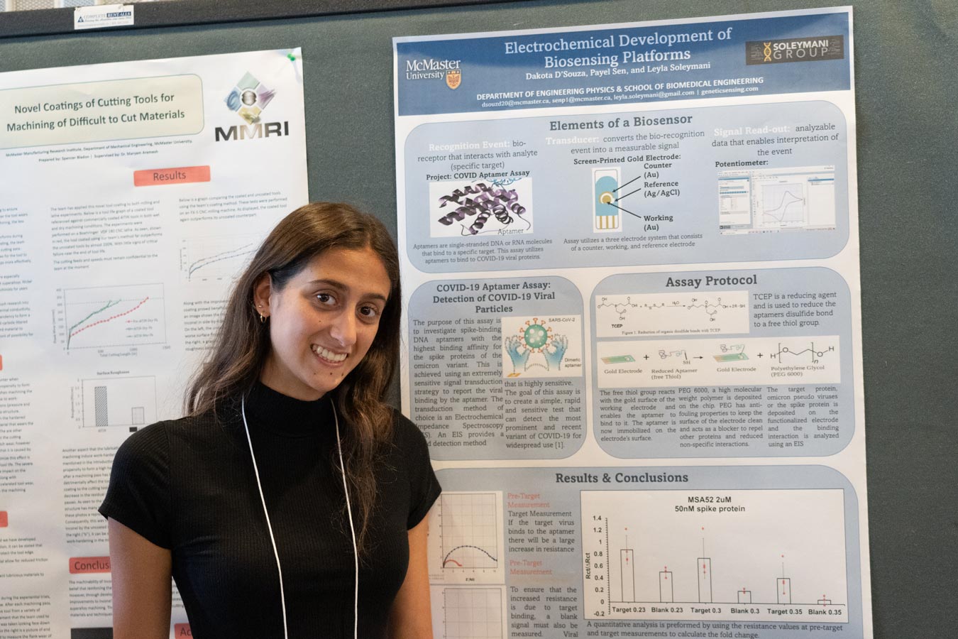 A student stands in front of her research poster