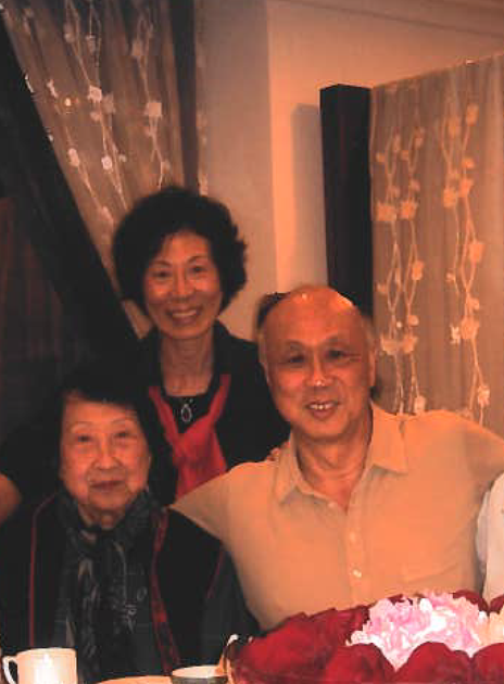Max Wong, his sister and his mother pose for a photo at a table.