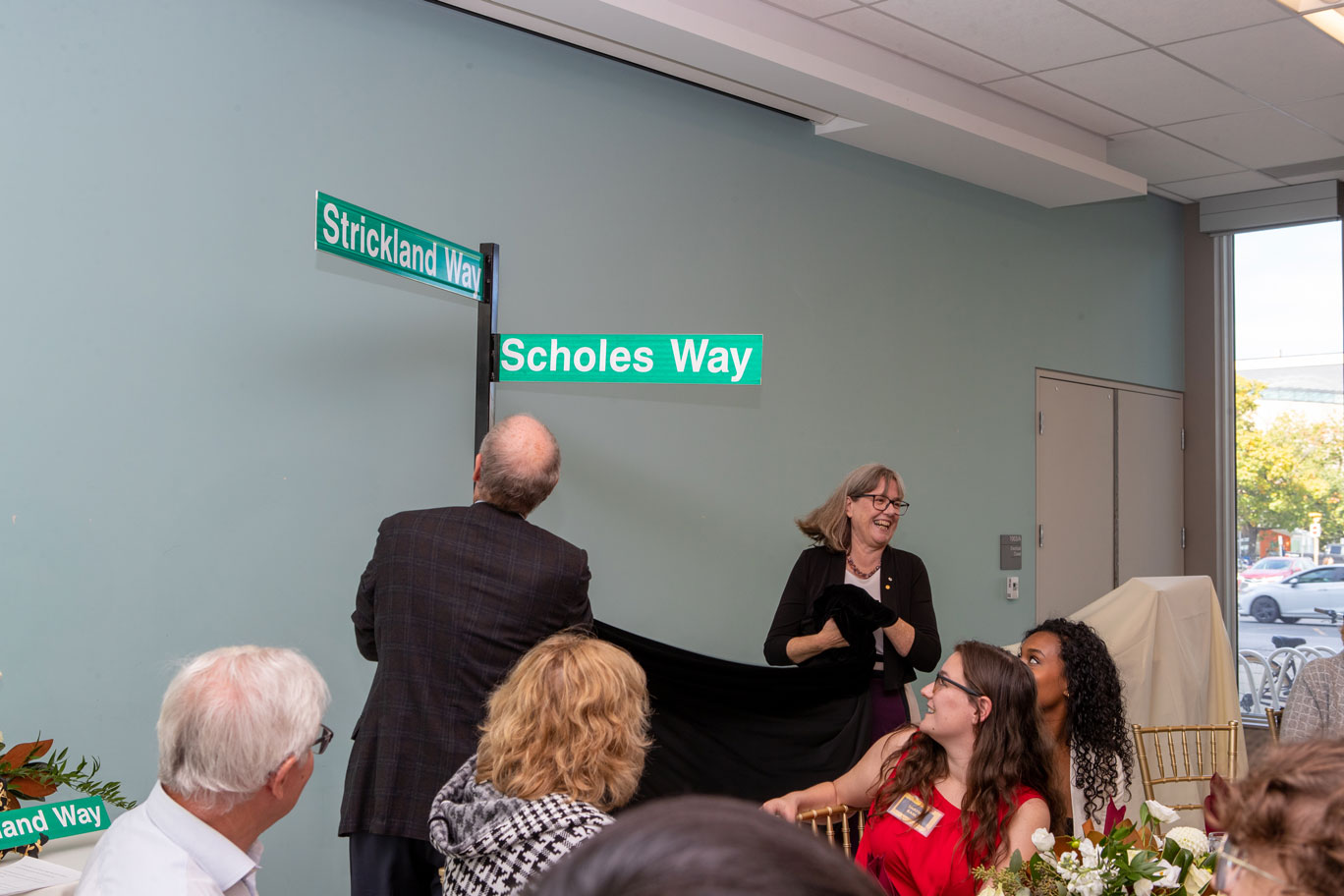 Donna Strickland and David Farrar pull off a cloth revealing the Strickland and Scholes Way street signs