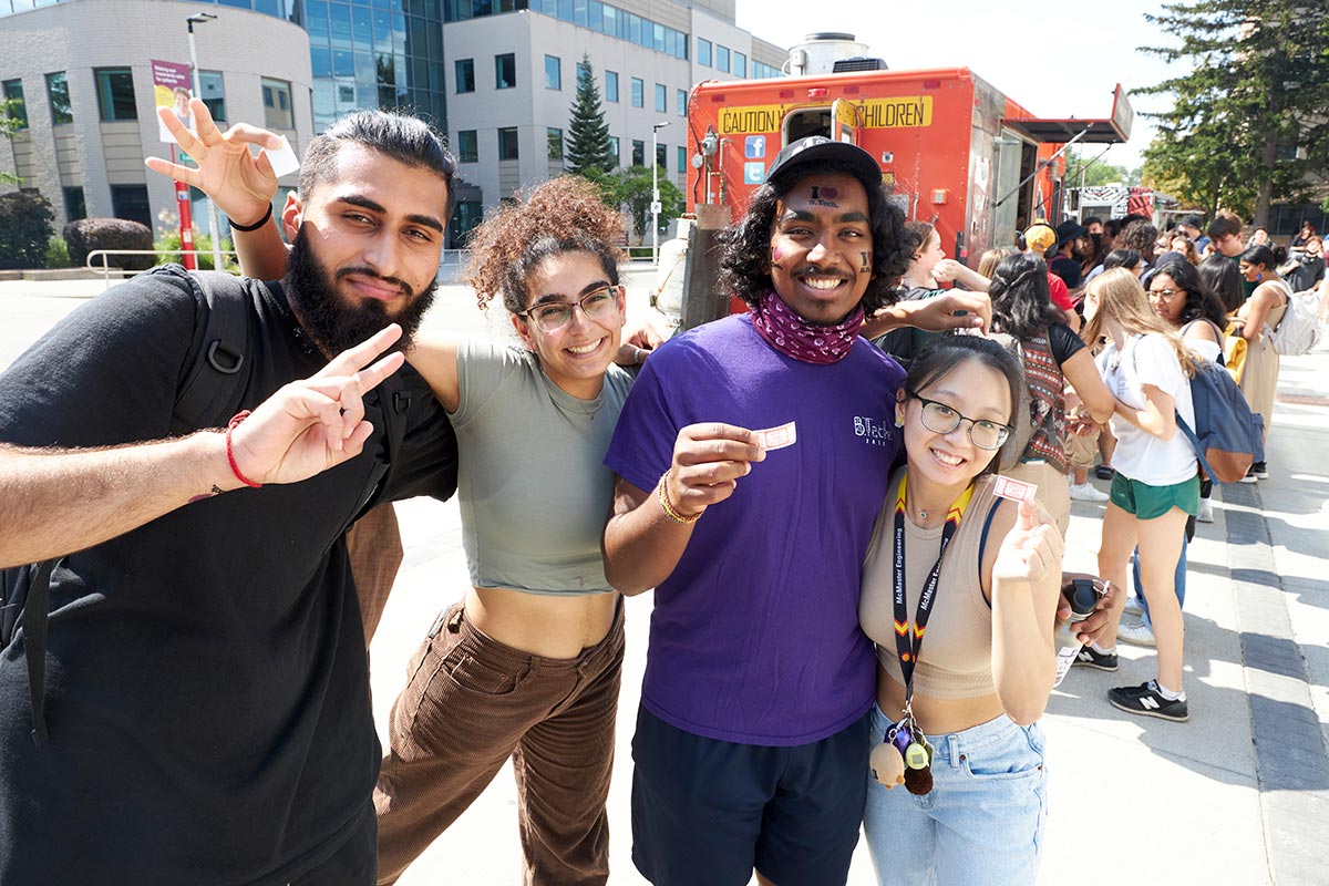 A group of students stands in front of the Dirty South food truck